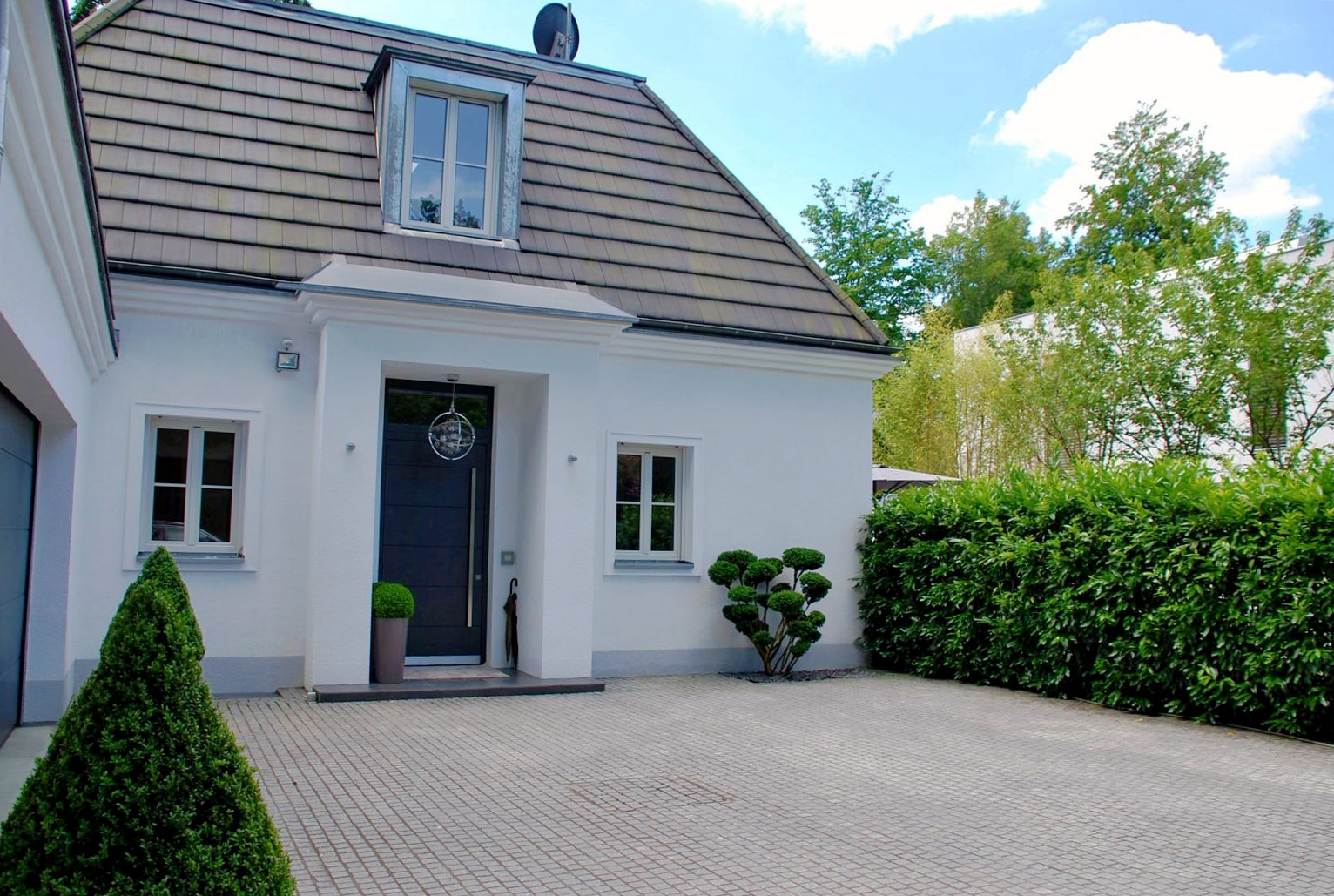Heller Hauseingang mit gepflastertem Vorplatz